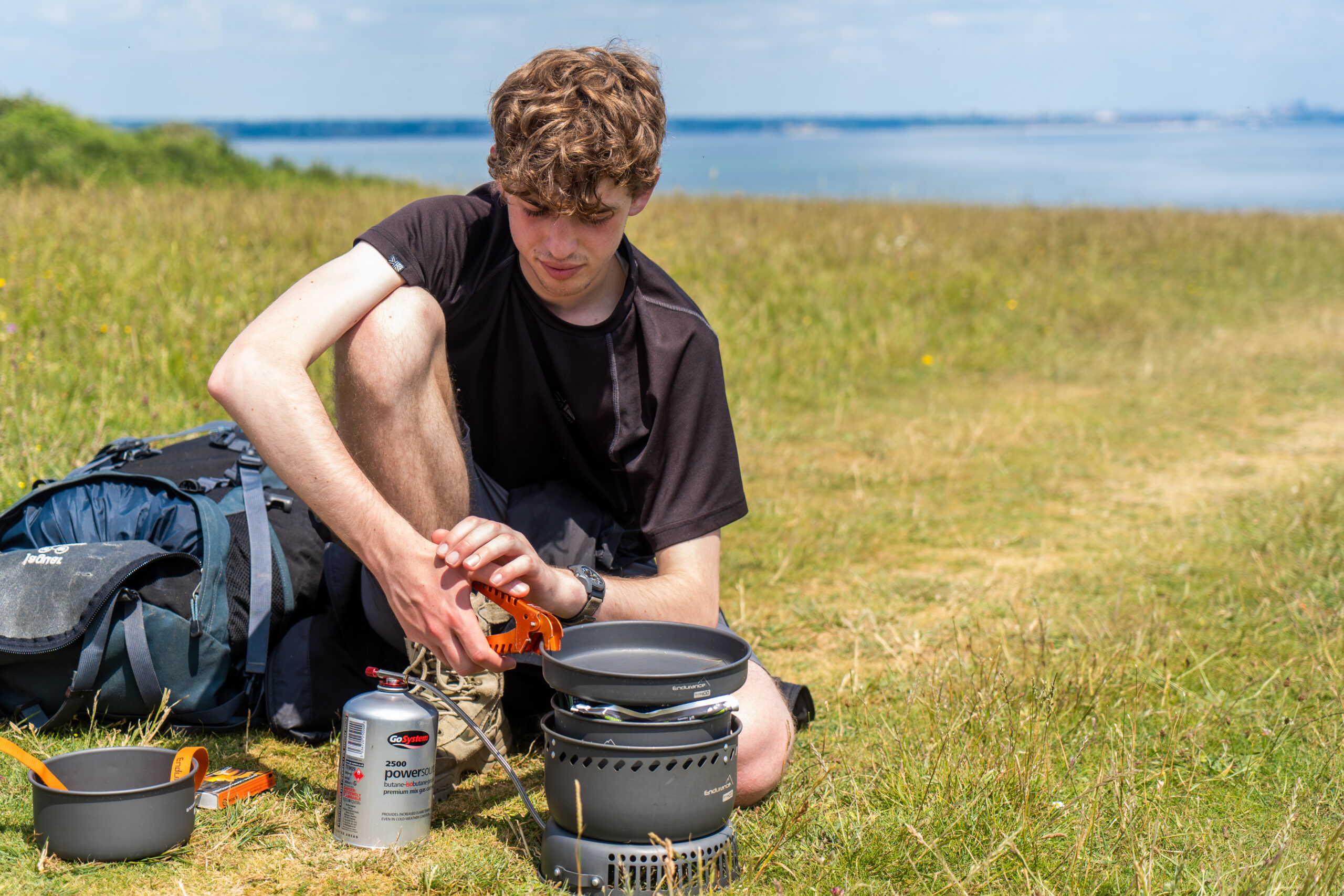 Duke of Edinburgh participant cooking a meal on a camping stove on their DofE expedition with School of Outdoors.